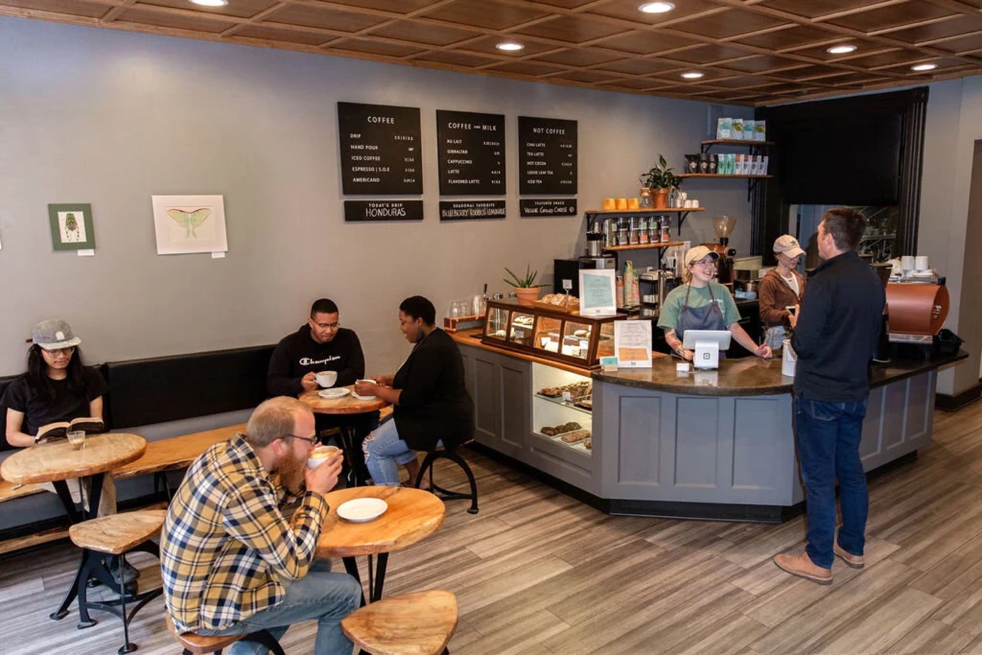 Customers and baristas in the cafe on a busy morning